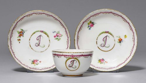 TEA CUP AND 2 SAUCERS FROM A TEA SERVICE WITH JL MONOGRAM,Nyon, ca. 1781-1813. Painted with a monogram medallion. Surrounding, purple edge with gold garlands and 'dentils d'or' border. Gilding and enamel colours partly rubbed. Provenance: Private collection, Geneva.