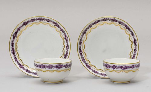 2 TEA CUPS AND SAUCERS,Nyon, ca. 1781-1813. Painted with a purple floral border over festoons in gold. Underglaze blue fish marks. Provenance: Private collection, Geneva.