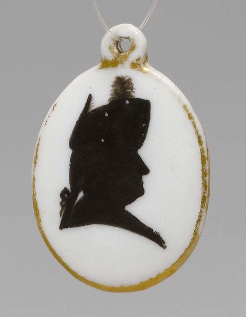 PORCELAIN PENDANT WITH SILHOUETTE PORTRAIT AND GOLD MONOGRAM,Nyon, ca. 1781-1813. H 4 cm. Gilding rubbed. Provenance: Private collection, Geneva.