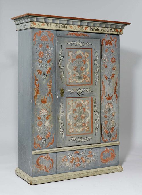 A PAINTED ARMOIRE, Toggenburg, inscribed JGF. URSULA .RÖSENE.. and dated 1775. Pine with painted decoration on blue ground. 136x55x185 cm. Few losses.