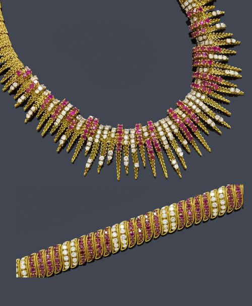 A RUBY AND DIAMOND NECKLACE AND BRACELET, France, ca. 1950. Yellow gold 750 and platinum, 222g. Elegant, textured necklace with a mesh pattern and with appliqued, ray-like motifs, the top decorated with 118 rubies weighing ca. 9.00 ct und 162 brilliant-cut diamonds weighing ca. 8.10 ct, irregular setting. French marks and maker's mark RS, L 41 cm. Matching elegant bracelet, the convex top set throughout with 168 rubies weighing ca. 10.00 ct and 84 brilliant-cut diamonds weighing ca. 3.70 ct, L ca. 19.5 cm.