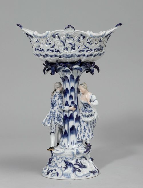 CONFECTIONERY BASKET,Meissen, ca. 1900. Open-worked basket over a rocaille base with a shepherd and shepherdess, painted in blue. Underglaze blue sword mark. Fire cracks.