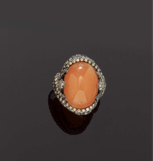 MOONSTONE AND DIAMOND RING. White gold 750. Fancy model, set with 1 oval, orange-coloured moonstone of ca. 18.00 ct, crossed band motif mounting, entirely set with numerous cognac-coloured brilliant-cut diamonds totalling ca. 3.20 ct. Size ca. 54.