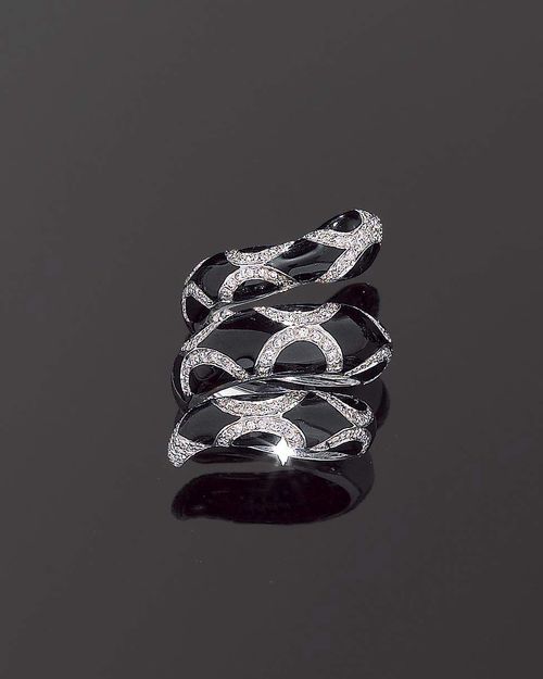 ENAMEL AND DIAMOND RING. White gold 750. Decorative ring in the shape of a double-coiled snake, the top is decorated with a motif of black enamelled scales and set with small brilliant-cut diamonds totalling ca. 0.80 ct. Size ca. 55.