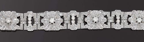 DIAMOND BRACELET, ca. 1945. Platinum. Decorative bracelet of 4 stylized floral motifs, set with 4 brilliant-cut diamonds totalling ca. 2.60 ct, inter-connected by means of 3 geometircally open-worked intermediate links are decorated with 6 brilliant-cut diamonds totalling ca. 1.30 ct. and additionally set with 328 octagonal diamonds totalling ca. 9.00 ct. L 18 cm. With copy of the insurance estimate, Gübelin, March 1993.