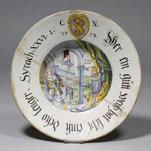 DECORATIVE PLATTER,Winterthur, dated 1678. Painted by Werkstatt Pfau. Painted with a Biblical scene (ISAM 19 CAP). The rim inscribed "WER EIN GUTT WEYB HAT LEBT EINST DESTO LÄNGER. SYRACH XXVI". Coat-of-arms with monogram CN and dated 1678. D 35.5 cm. Strong damage and repairs.