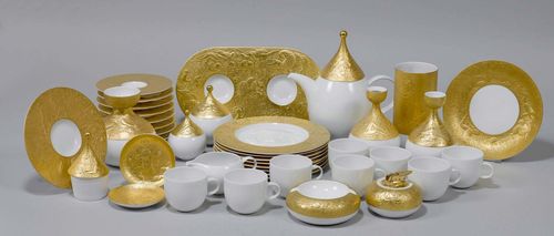 BJØRN WIINBLAD (1918 - 2006) COFFEE AND DESSERT SERVICE, "Magic Flute" model for Rosenthal. Porcelain with gold decor in relief. Comprising:  8 plates, 8 cups with saucers, 2 trays, 2 small bowls, 3 carafes, teapot, cream jug and sugar bowl on a tray, 1 sugar pot, 1 ashtray, 1 table lighter, 1 vase, 1 lidded box.