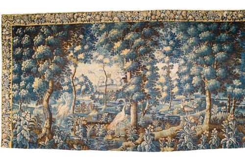 LARGE TAPESTRY,Early Baroque, probably  Flemish, 17/18th century Idealised forest landscape with animals and buildings in the background. Rich floral and foliate border, some losses. Shortened. H 254 cm, W 458 cm. Provenance: West Swiss private collection. An identical tapestry is in the Hermitage in St. Petersburg.