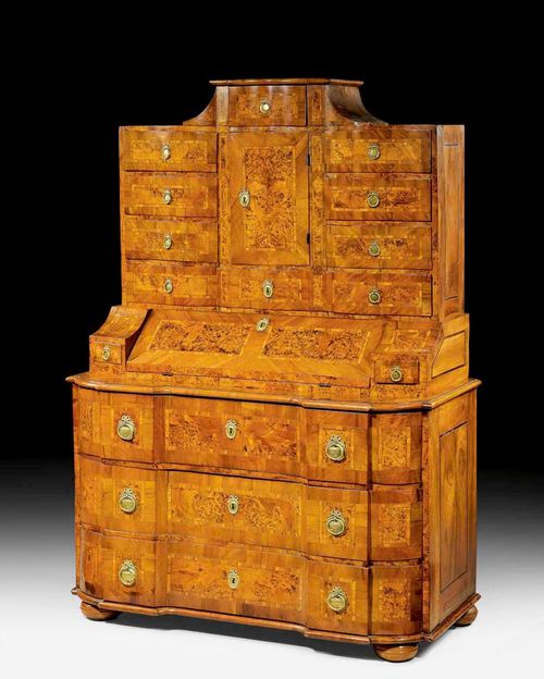 BUREAU CABINET,Baroque, probably Austria circa 1760. Walnut, burlwood and pearwood veneer and inlaid with reserves and fillets. The shaped front with 3 drawers under hinged writing surface between 2 small drawers. The fitted interior with large compartment and 4 drawers. The recessed upper section with central drawer and 5 drawers and a fitted interior of 4 small drawers and 2 arched niches. 130x61x(open 75)x175 cm. Provenance: Private collection, West Switzerland.