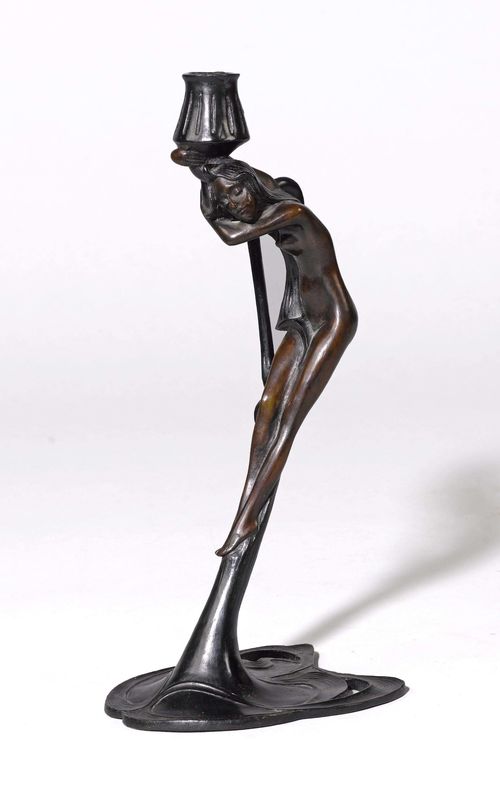 CANDLESTICK, Art Nouveau. Bronze with black and brown patina. Designed as a woman. With a conical nozzle. H 37.5 cm.