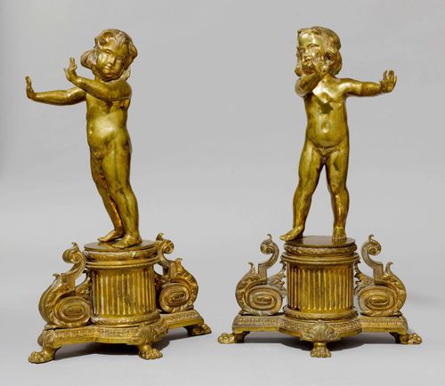 PAIR OF FIREPLACE CHENETS,Napoleon III, France. Bronze. Standing putti with outstretched arms. On a cylindrical, fluted base. H 51.5 cm.