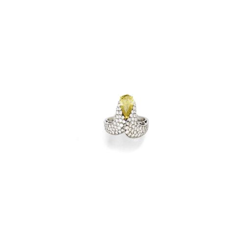 DIAMOND RING. White gold 750. Decorative ring, the top designed as a stylized loop set with 1 yellowish, drop-cut diamond weighing 1.20 ct, type IIA, and pavé-set with numerous brilliant-cut diamonds weighing ca. 1.40 ct. Size ca. 55. Oral estimate by GGTL/Gemlab.