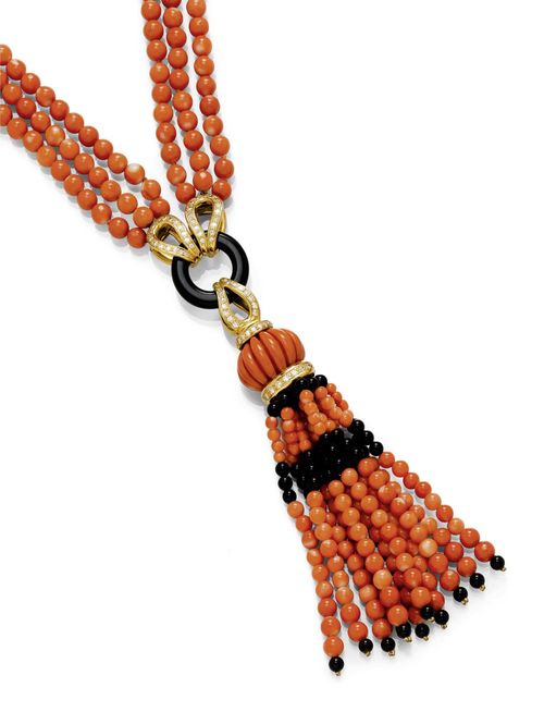 CORAL, ONYX AND DIAMOND SAUTOIR. Yellow gold 750, Total weight ca. 150g. Decorative, three-row "Y"-shaped necklace of numerous salmon corals of ca. 5.5 mm Ø, the ends set with diamonds and 1 onyx ring. With a removable pendant of 1 coral/onyx tassel, suspended from 1 oval, ribbed coral of ca. 20 x 13 mm and 1 clip eyelet set with diamonds. Total weight of the diamonds ca. 1.20 ct. L ca. 75 cm.