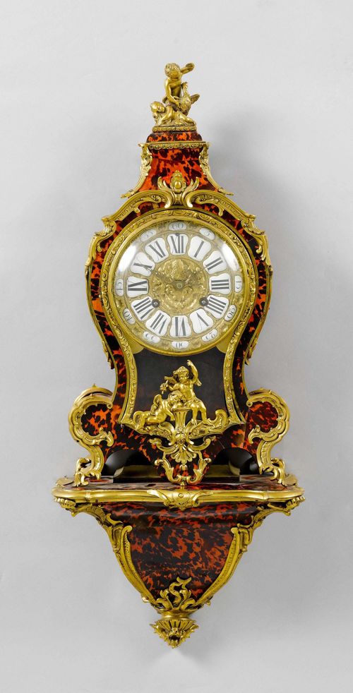 CLOCK ON PLINTH,late Louis XV, France, 19th century. Curved wooden case, decorated with red tortoiseshell. Bronze mounts designed as rocailles, leaves, shells and putti. Bronze dial with white enamel cartouches. Movement with anchor escapement striking the 1/2-hour on bell. H 86 cm. Provenance: - from a Swiss private collection.