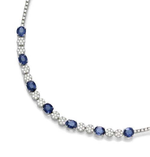 BURMA SAPPHIRE AND DIAMOND NECKLACE. White gold 750, 29g. Decorative, elegant Rivière necklace, the front set with 7 oval Burma sapphires weighing 11.11 ct in total, each connected to one another by means of two rosette motifs set with diamonds. Total weight of the brilliant-cut diamonds ca. 7.30 ct. L ca. 40.5 cm. With Stalwart Report No. 123969, February 2013.