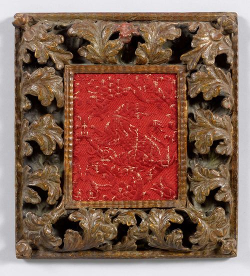 SMALL FRAME,Spain, 16th century. Wood, finely carved. Rectangular frame with circumferential , open-worked leaf decoration. Red fabric fragment depicting a lion. 32.5 x 37.5 cm.