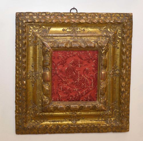 LOT  OF 2 SMALL FRAMES,Spanish, 17th/18th century. Wood, carved, gilt and painted grey. Rectangular, decorated with leaves, the centre with a red fabric fragment depicting a lion. Dimensions 15 x 17.5 cm; 39 x 41 cm and 21.5 x 17.5 cm; 38 x 33.5 cm.