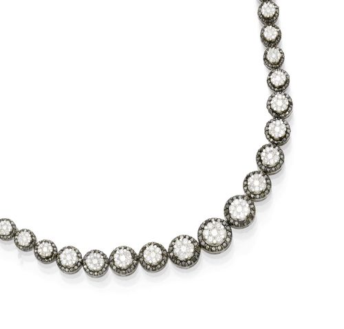 DIAMOND NECKLACE. White gold 750, partially blackened. Decorative necklace of 67 graduated links, each with the centre set with 7 diamonds forming a rosette, within a border of numerous black diamonds. Total weight of the diamonds ca. 9.50 ct. L ca. 41.5 cm. Matches the following lot.