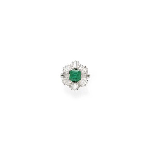 EMERALD AND DIAMOND RING, ca. 1950. Platinum. Classic-elegant ring, the top set with 1 step-cut emerald weighing ca. 1.80 ct, minimal signs of wear, within a border of 30 trapeze-cut diamonds weighing ca. 3.70 ct. Size ca. 55.
