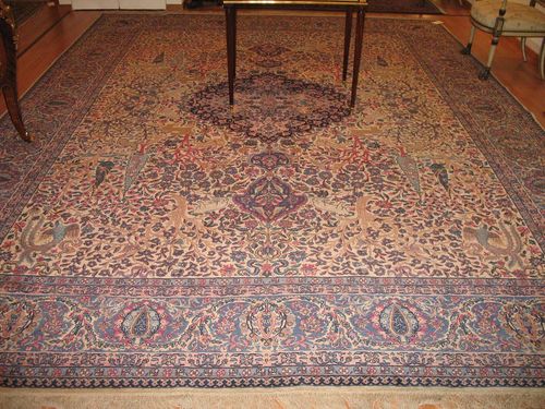 KIRMAN old.Beige central field with pink central medallion, the entire carpet is finely patterned with plants and animals in attractive pastel colours, slight wear, 400x300 cm.