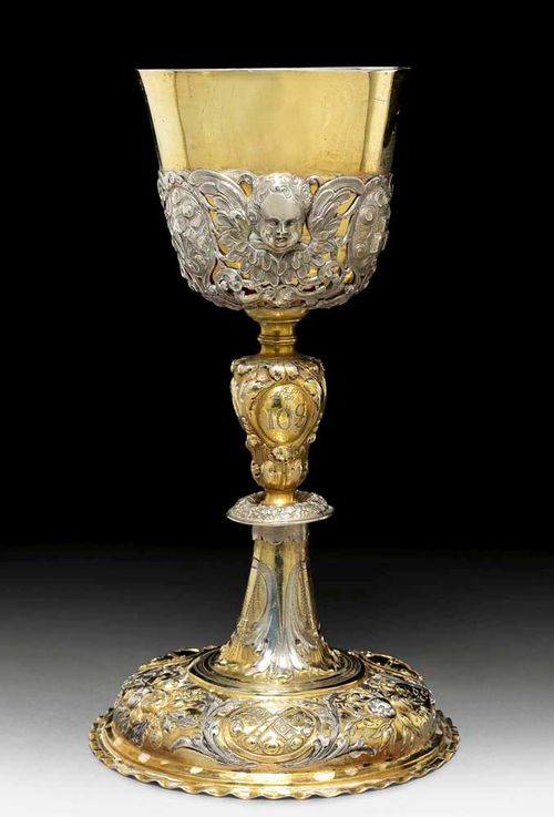 CUP FOR EVENING MEAL. Augsburg, 1708-10.Maker's mark  Ludwig Schneider. Parcel gilt. Chased and embossed with floral and foliate decoration. The cup with openwork mount with winged angels' heads. H 25 cm. 541 g.