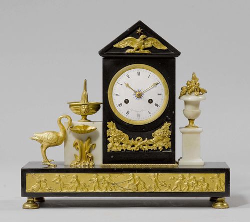 MANTEL CLOCK,Empire/Restoration, the dial signed DESCHAMPS A PARIS. Black and white marble and gilt bronze. White enamel dial. Parisian movement, striking the 1/2-hour on bell. 38x14x36 cm.