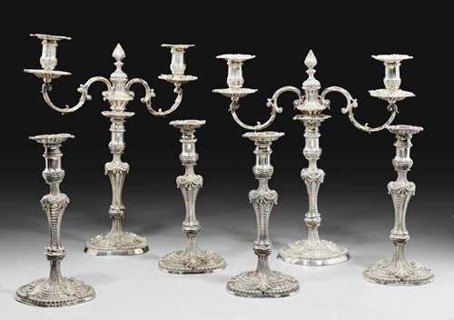 SET OF 4 CANDLE HOLDERS AND 2 CANDELABRAS.The candle holders London 1806 with maker's mark  John Mewburn. The candelabras lower section 1809 John Mewburn. The candelabras upper section later replaced by Robert Garrard 1860. Relief decorated with rocaile, shells and gadrooning. Candle holders H 29 cm. Candelabras H 42.5 cm. Total 10370 g.