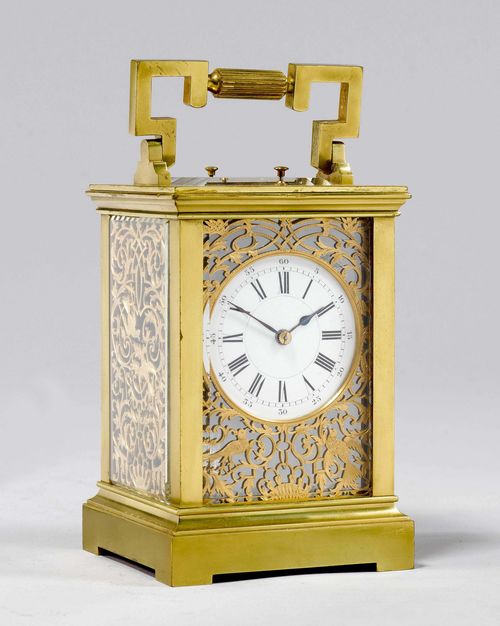 TRAVEL CLOCK,England ca. 1880. Brass. Rectangular case with handle, glazed on all sides. The front and sides, pierced and engraved. White enamel dial. Movement with balance, striking mechanism striking the 1/2-hour on gong. Repetition of the hour and 5-minutes on demand. 9x8x14 cm. Striking mechanism requires revision.