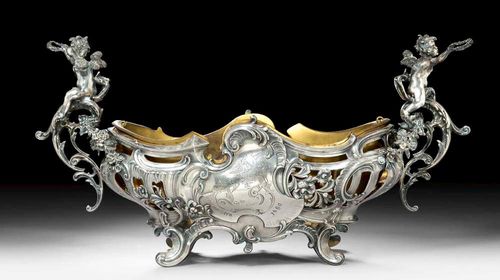 ART NOUVEAU JARDINIÈRE. Dated 1890Openwork on all sides with scrolls, acanthus and rocaille. The shaped handles decorated with putti and floral festoons. With brass liner. L 54 cm. 1320 g.