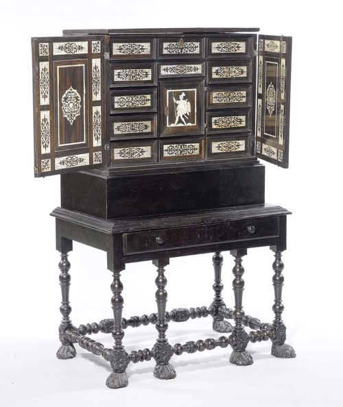 CABINET ON A STAND,Baroque, Germany or Holland, 17th century. Ebony, walnut and bone, engraved and opulently inlaid with tendrils, birds, and warriors. Rectangular body with hinged top. The front with double-doors opening up into 9 drawers and a door, in turn opening up into 4 drawers. Metal handles. On a later stand with turned frame and animal feet. 77x47x124 cm. 1 key. The drawers behind the central door and the interior fittings below the hinged cover, not original.