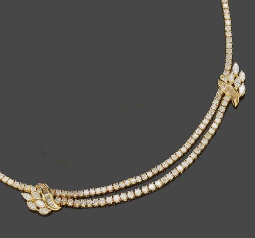 DIAMOND NECKLACE. Yellow gold 750. Attractive Rivière model, set with 208 brilliant-cut diamonds, the flower-shaped transition to the front side additionally decorated with 10 navette-cut diamonds and 24 baguette-cut and trapeze-cut diamonds. Total weight of the 242 diamonds ca. 15.00 ct. L ca. 42 cm.