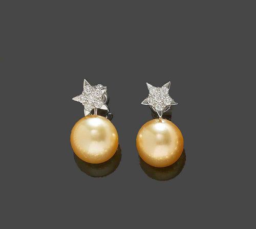 PEARL AND BRILLIANT-CUT DIAMOND STUD EARRINGS. White gold 750. Decorative stud earrings, each consisting of 1 naturally yellow South Sea cultured pearl of ca. 12.9 mm Ø and fine lustre, mounted below a star motif set with 6 brilliant-cut diamonds totalling ca. 0.60 ct. Matches the  previous lot.