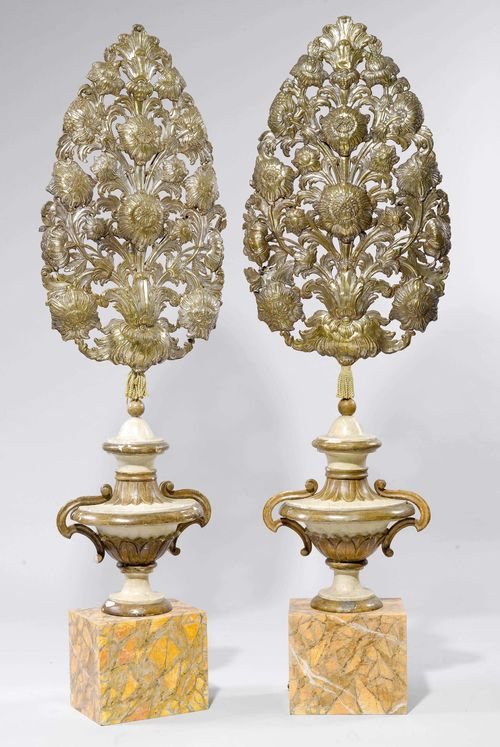 PAIR OF CHASED BRASS ELEMENTS MOUNTED AS FLOOR LAMPS,Baroque and later, Italy. Pierced brass, chased with flowers and leaf volutes. Remains of gilt and silver plating. Mounted on a painted wooden shaft designed as a vase, on a rectangular plinth. H 212 cm, W 63 cm.