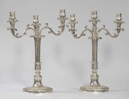 PAIR OF CANDELABRAS,in the style of Louis XVI. Metal, silver-plated. Vase-shaped foot, decorated with grooves and leaves. 3 light branches and trumpet-shaped nozzles. On a gadrooned, round base with circumferential beading. H 54 cm.