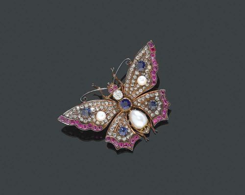 GEMSTONE, PEARL AND DIAMOND BROOCH, ca. 1900. Red gold. Very decorative brooch in the shape of a butterfly, the body set with 1 old-mine-cut diamond of ca. 0.30 ct, 1 sapphire of ca. 0.54 ct and 1 egg-shaped pearl, the wings set with 110 rose-cut diamonds totalling ca. 1.00 ct and with 4 sapphires totalling ca. 1.00 ct. The outer rim of the wings and the eyes adorned with 36 rubies totalling ca. 1.40 ct. Removable clasp, pin in yellow gold.