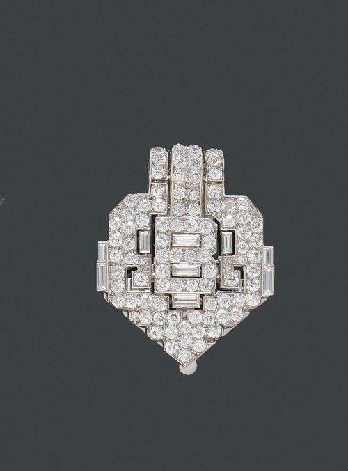DIAMOND CLIP, CARTIER, London, ca. 1930. Platinum. Elegant, geometrically-shaped Art Déco clip, the open-worked surface set with 9 baguette-cut diamonds totalling ca. 1.00 ct and with 87 brilliant-cut diamonds totalling ca. 3.00 ct. Engraved: Barbara Briggs, June 9th, 1934. Signed: Cartier London.