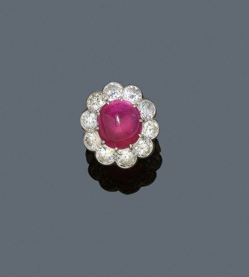 RUBY AND DIAMOND RING, ca. 1930. Platinum. Elegant Ring, the top set with 1 Burma ruby cabochon of ca. 17.00 ct, unheated and oiled, surrounded by 10 old mine cut diamonds totalling ca. 5.50 ct. Size ca. 48. Gemlab-certified.