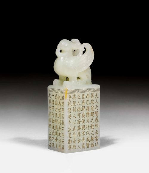A WHITE JADE SEAL WITH A PHOENIX CARVED IN THE ROUND AND A GILT INSCRIPTION. China, Height 10 cm. Fabric box.
