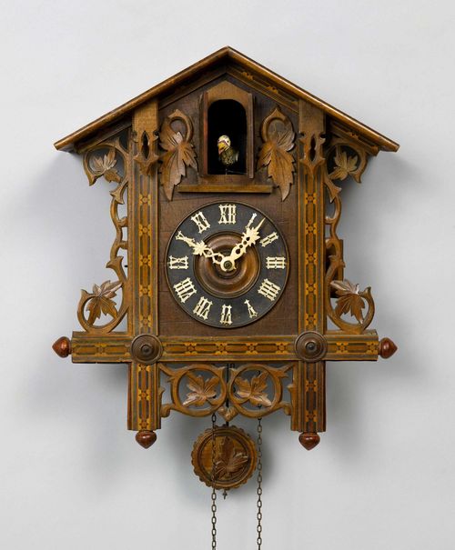 CUCKOO CLOCK,Black Forest, ca. 1900. Pinewood. Case designed as a house with pierced tendrils. Movement with anchor escapement and cuckoo call as well as strike on gong. H 46 cm.