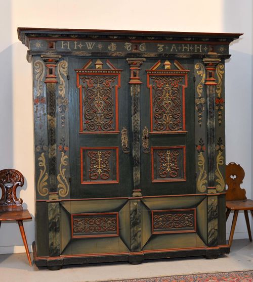 PAINTED CUPBOARD,late Renaissance, Toggenburg, dated 1763 and monogrammed HIWAHH. Pinewood and cherry carved with grotesque figures and tendrils, and painted with leaf volutes and flowers, and partly marbled. Front with double-doors flanked by 2 pilasters. Metal escutcheons. 195x69x203 cm. 1 key. Some losses. Painting, re-touched in parts.