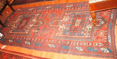 FACHRALO old.Red ground with two medallions, the entire carpet is geometrically patterned with depictions of plants, human beings and animals, triple stepped border, signs of wear, 240x115 cm.