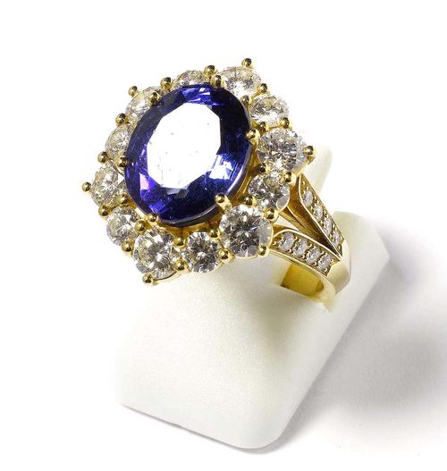 TANZANITE AND BRILLIANT-CUT DIAMOND RING, PATEK PHILIPPE, ca. 1999. Yellow gold 750. Elegant, classic model, the top set with 1 oval tanzanite of 5.52 ct and very fine quality, in a brilliant-cut diamond surround. The ring shoulders additionally set with 16 smaller brilliant-cut diamonds. Total weight of the brilliant-cut diamonds 2.43 ct. Ref. 275J/Series No. 37924. Size 52. With case and copy of insurance estimate from Patek Philippe, 1999.