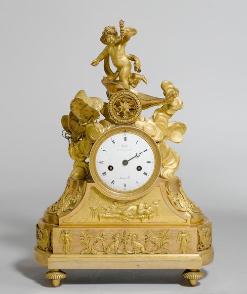 MANTEL CLOCK,Restoration, Paris, ca. 1820, the dial signed GALLE RUE VIVINENNE A PARIS (Claude Galle, maître 1786) and THOMAS HGER. Gilt bronze. Rectangular, stepped case. The top decorated with Cupid in a small chariot pulled by 2 butterflies. White enamel dial (slightly chipped). Parisian movement, striking the 1/2-hour on bell. H 43 cm. 1 hand and Cupid figure, broken-off. Requires repair.