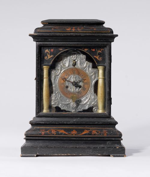 TABLE CLOCK WITH FRONT ZAPPLER,Austria, mid-19th century. Silver-plated, chased dial with copper chapter ring and scrolled feet. Mounted in a rectangular, wooden case, blackened and painted with garlands. Movement with verge escapement and front pendulum. Striking mechanism with bell. Repetition on demand. H 41 cm. Striking mechanism requires servicing.