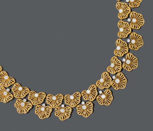 GOLD AND BRILLIANT-CUT NECKLACE, ca. 1940. Rosé and white gold 750. Very fancy, rare necklace of stylised, open-worked lotus leaves, arranged in a double-row on the front, each set with 1 brilliant-cut diamond in the middle. The top is additionally adorned with and spaced by 15 brilliant-cut diamonds. A total of 55 brilliant-cut diamonds totalling ca. 6.50 ct in white gold prong settings. Integrated fastener. L ca. 42 cm. Designated as Bulgari. With case.