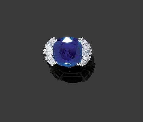 MADAGASCAR SAPPHIRE AND DIAMOND RING. Platinum 900. Very elegant ring, the top set with 1 rare, untreated sapphire from Madagascar, of 14.00 ct, cushion-shape and very fine quality in royal blue, flanked by 6 diamond droplets totalling ca. 2.40 ct. Size 55. With Report No. 0611095 from  Gübelin-Gemlab, 2006.