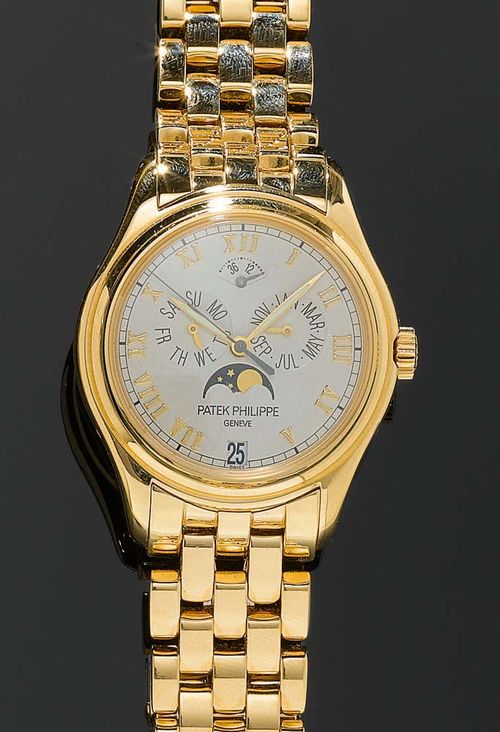 GENTLEMAN'S WRISTWATCH, PATEK PHILIPPE, AUTOMATIC WITH MOON PHASE. Yellow gold 750. Round case No. 4188559 with exposition back. Silver-coloured dial with appliqued gold Roman numerals, month and day indicators, moon phase indicator, annual calendar, date window at 6h. Ref. 5063/1J-001. Automatic with moon phase, movement No. 3287148, Cal. 315 S IRM QA. Gold band with fold-over fastener. Hardly worn, with case. Papers available.