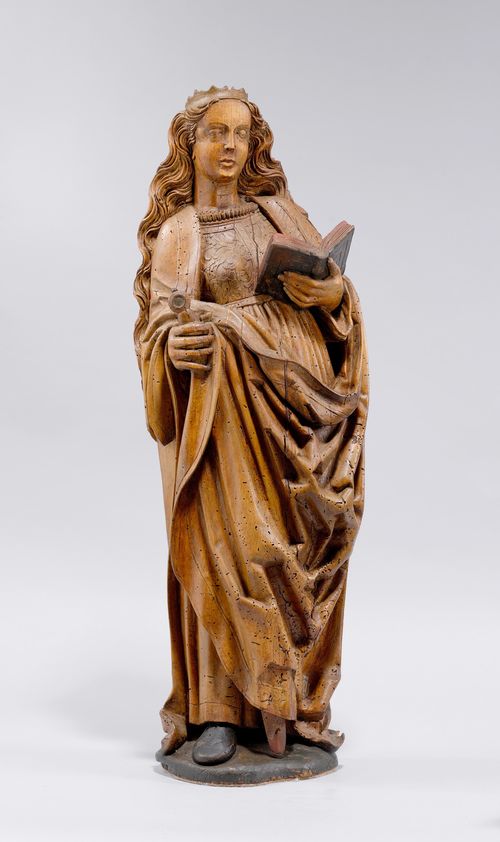SAINT CATHERINE,late Gothic, Flanders, 1st half of the 16th century. Lime, carved and verso in part flattened. The saint is holding a book and a sword, and wearing a belted gown. H 82 cm. Repaired in the region of the face and on the base.