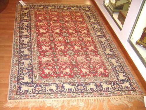 KAYSERI silk, old.Red central field patterned throughout with white lions and green plants, blue border, good condition, 195x125 cm.