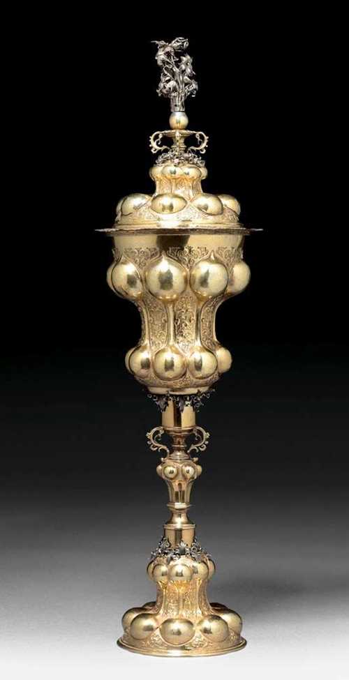 LARGE SILVER-GILT LIDDED CUP. Probably Nuremberg,unmarked, chalice, foot and lid humpbacked all around, interspersed with plant relief ornaments. Polygonal node on the shaft. Finely chased leaf and floral ornaments on the shaft lid. H 70 cm. 420 g.
